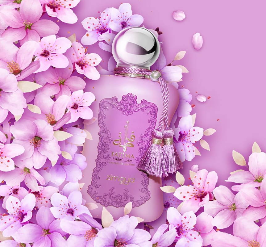 Zimaya Fatima Velvet Love pink bottle with silver ball cap and twin tassels, surrounded by pink blossoms and loose petals on a pink background.