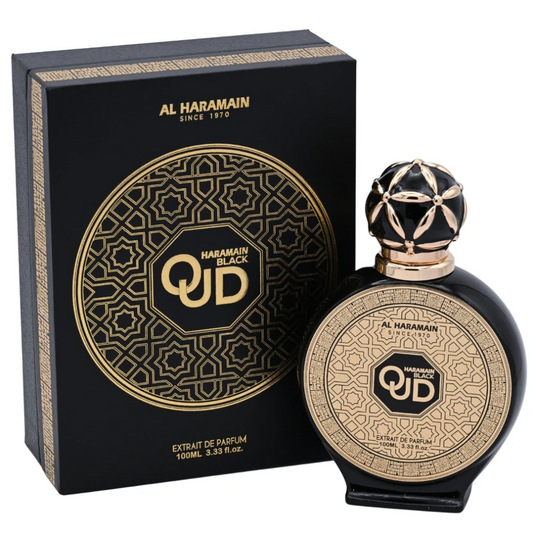 Al Haramain Black Oud round black bottle with a gold geometric face and ornate black-and-gold spherical cap beside a matching patterned black box on white.