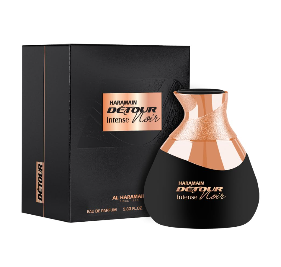 Al Haramain Detour Noir Intense black curved bottle with a rose-gold sculpted top beside a black box with a rose-gold label on a white background.