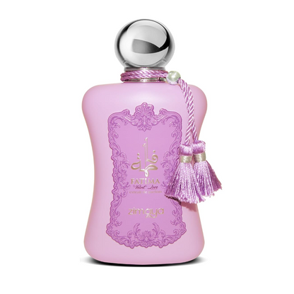 Zimaya Fatima Velvet Love pink bottle with curved sides, purple ornamental border, gold lettering, spherical silver cap and two pink-purple tassels, isolated on white.