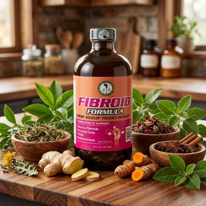African Indian Herbs Fibroid Formula bottle on a wooden board with herbs and root props