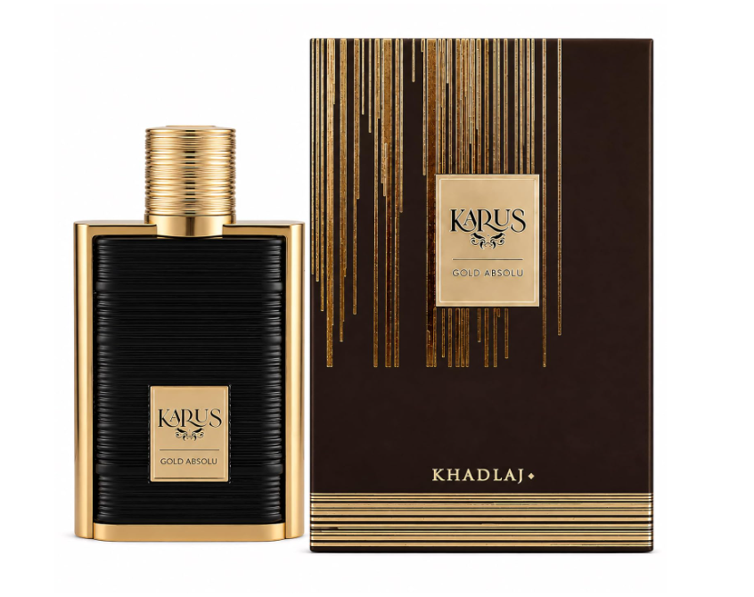 Khadlaj Karus Gold Absolu black ribbed rectangular perfume bottle with gold frame, gold plaque and ridged cylindrical gold cap, beside its brown-and-gold box on white.