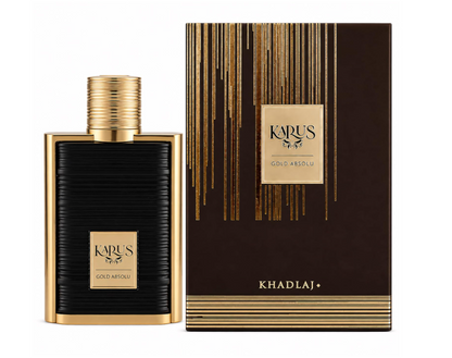 Khadlaj Karus Gold Absolu black ribbed rectangular perfume bottle with gold frame, gold plaque and ridged cylindrical gold cap, beside its brown-and-gold box on white.