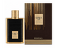Khadlaj Karus Gold Absolu black ribbed rectangular perfume bottle with gold frame, gold plaque and ridged cylindrical gold cap, beside its brown-and-gold box on white.