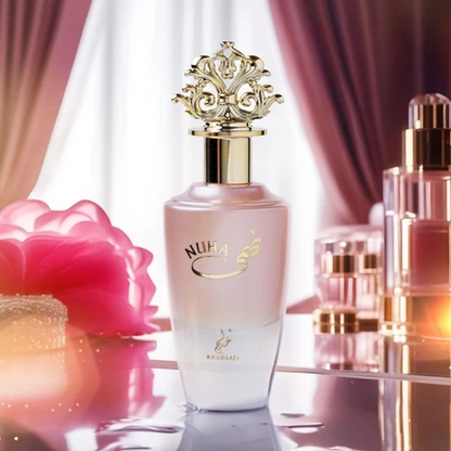 Khadlaj Nuha pink bottle on a vanity with a flower and burgundy curtains