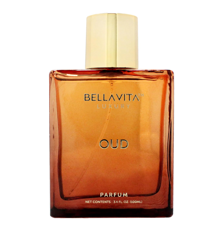 Close-up of Bellavita Oud Parfum in a deep amber rectangular bottle with a pale gold cap, dark Oud lettering and a visible spray tube on white.