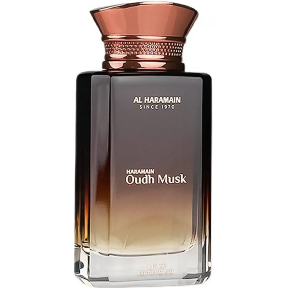 Al Haramain Oudh Musk perfume bottle fading from dark brown to clear, with white lettering and a flared copper-colored cap with a textured band on white.