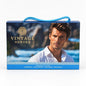 Vintage Heroes Pour Homme closed blue gift box with a rope handle and gold lettering