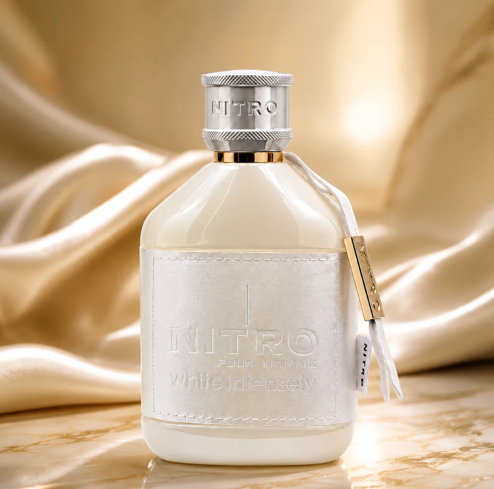 Dumont Nitro White Intensely ivory bottle with silver cap and white wrap, standing on a pale marble surface in front of draped champagne-colored satin.